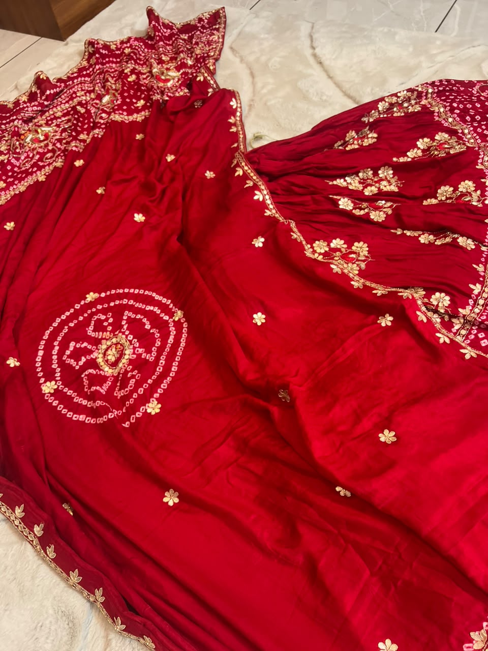 Beautiful Blood Red Gajji Silk Bandini Lehenga Set with Beautiful Gota Handwork all over the Lehenga and Dupatta. Comes with a beautiful Gajji silk blouse piece with gota work
