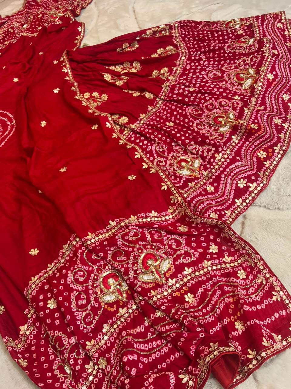 Beautiful Blood Red Gajji Silk Bandini Lehenga Set with Beautiful Gota Handwork all over the Lehenga and Dupatta. Comes with a beautiful Gajji silk blouse piece with gota work