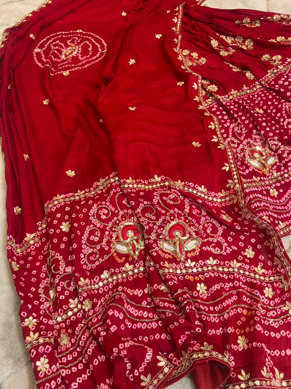 Beautiful Blood Red Gajji Silk Bandini Lehenga Set with Beautiful Gota Handwork all over the Lehenga and Dupatta. Comes with a beautiful Gajji silk blouse piece with gota work