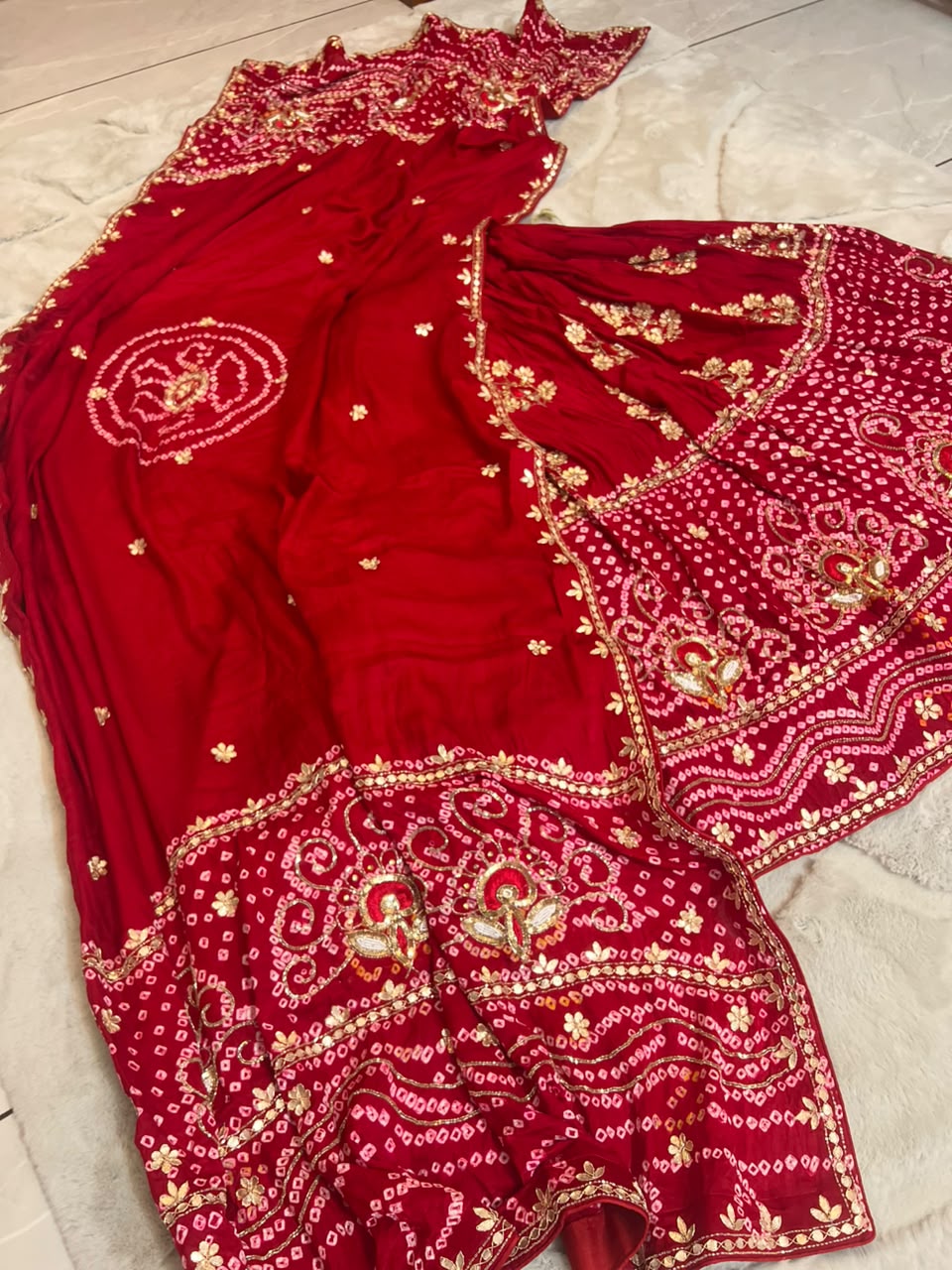 Beautiful Blood Red Gajji Silk Bandini Lehenga Set with Beautiful Gota Handwork all over the Lehenga and Dupatta. Comes with a beautiful Gajji silk blouse piece with gota work