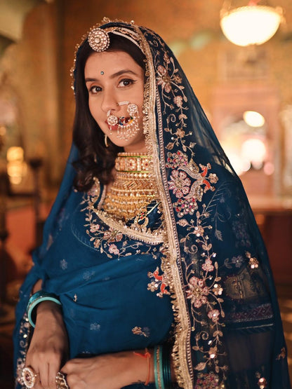 A masterpiece of grace — a peacock-inspired Royal Blue Poshak with a Royal Full Ghera and Pure, Luxurious Fabric. Timeless, Traditional, and Truly Breathtaking. (Stitched)