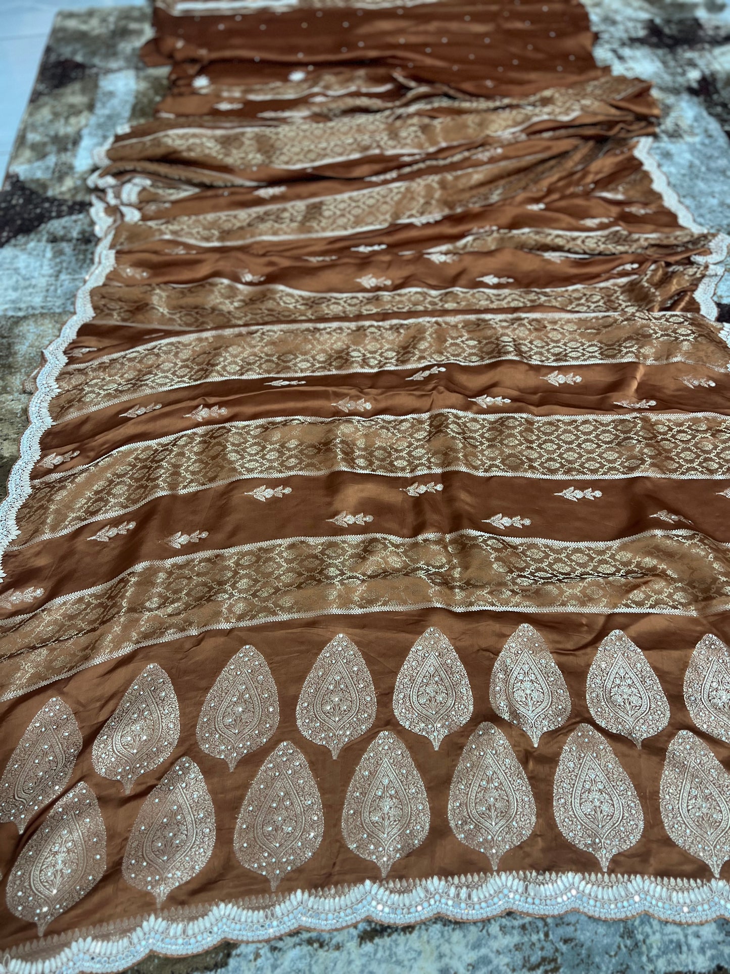 Beautiful Coffee colour Modal Silk Saree with lovely designer zari work on the border and the booties are made up of mirror, Gota and little bit of Zardozi touch.  And the blouse piece makes it look even more beautiful.