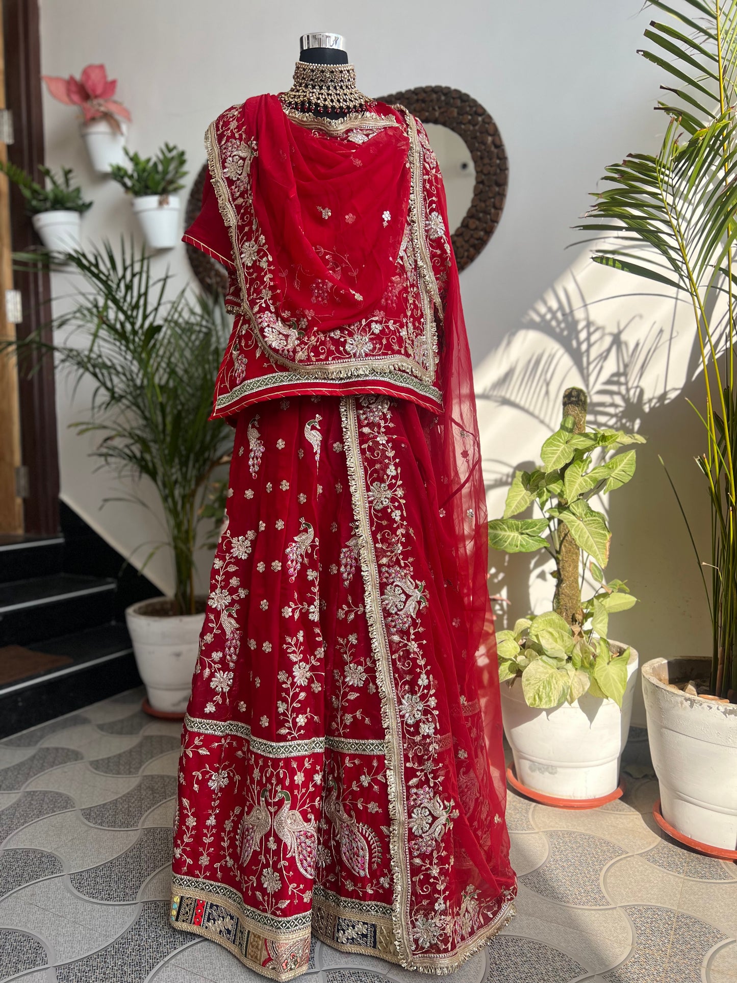 Royalty in every swirl — peacock motifs, full ghera, and the richness of pure fabric. A poshak that tells its own story. (Stitched).